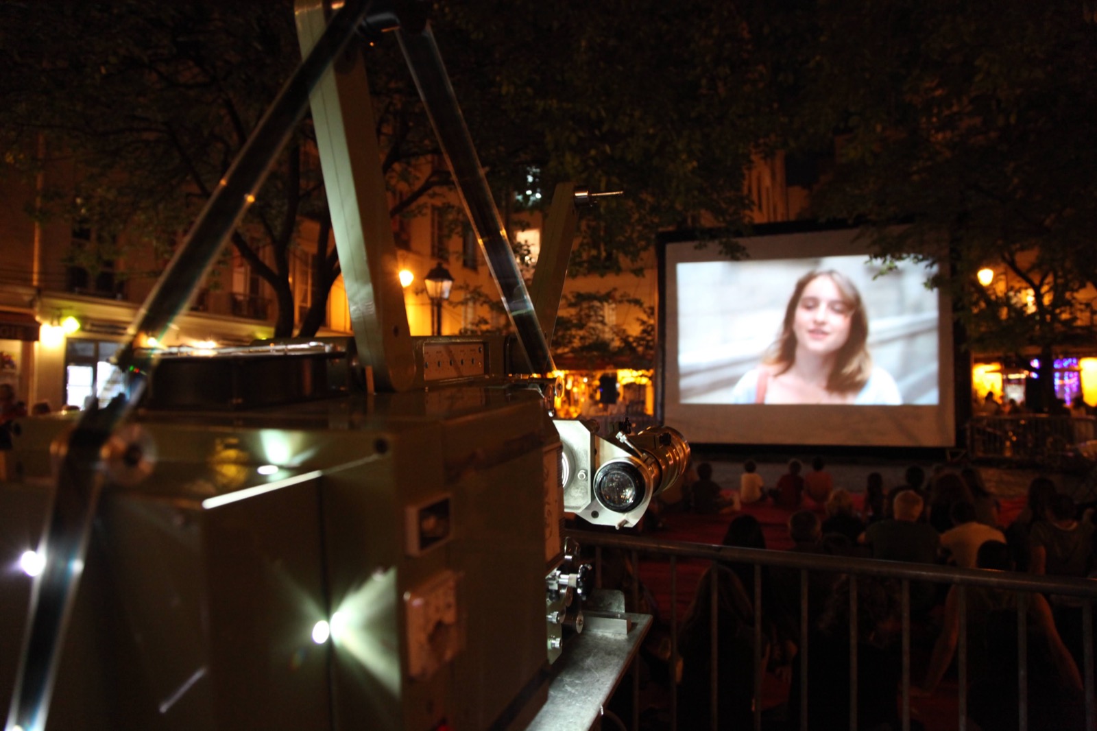 Open-air cinema screening on an inflatable screen; Hallucine cinema projector in the foreground